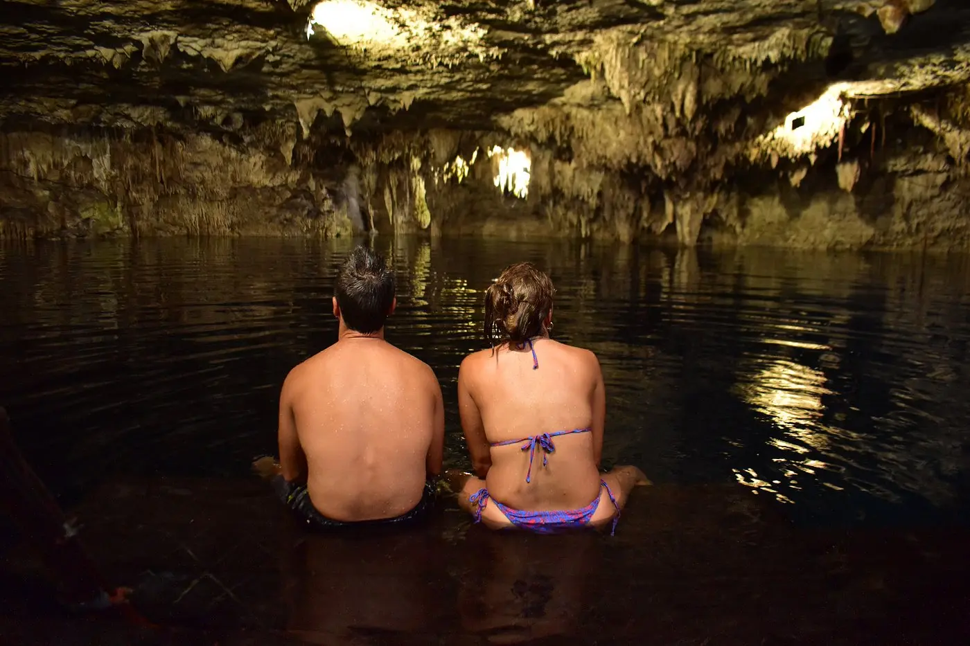 Visitantes contemplan el interior del cenote Kin-Ha